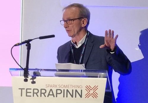 Man wearing glasses standing at a presentation lecturn