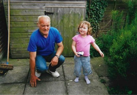 Dad kneeling down next to small girl.