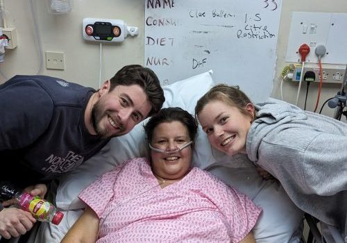 Clare Bullen 3 Female in hospital bed with male and female either side of her.