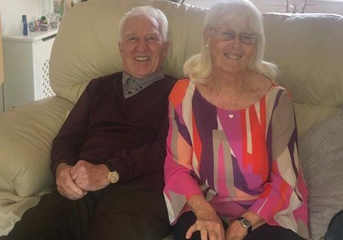 Dave and Linda Power sitting on the sofa in their home.