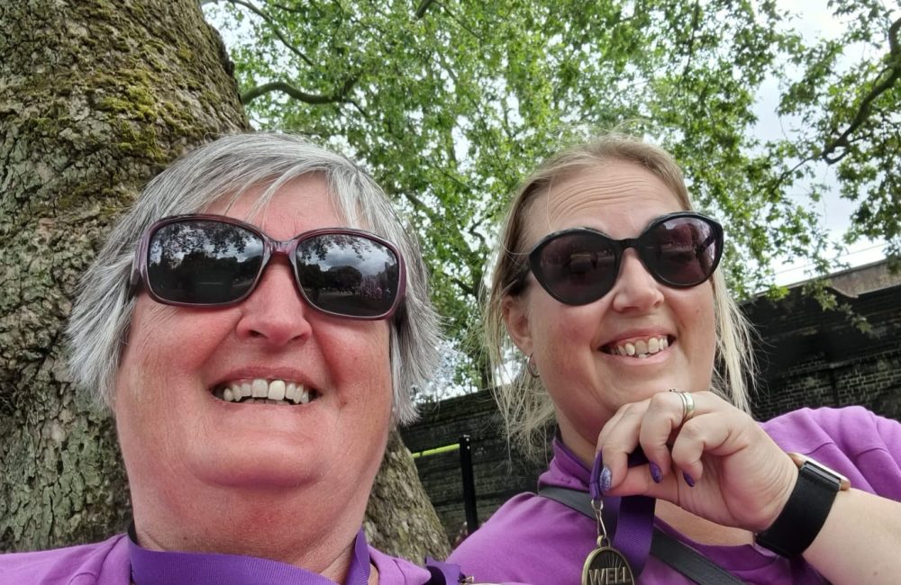 Mum and daughter wearing their purple t-shirts holding medals