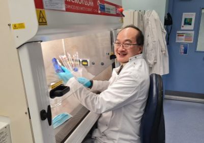 Dr Eddie Wang holding test tubes in his research lab