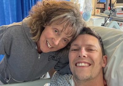 Son Luke, in hospital bed with his mum Gill next to him.