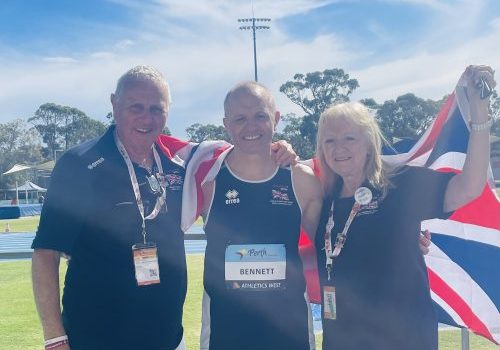 Two men and one female waving a Great Britain flag at the British Transplant Games