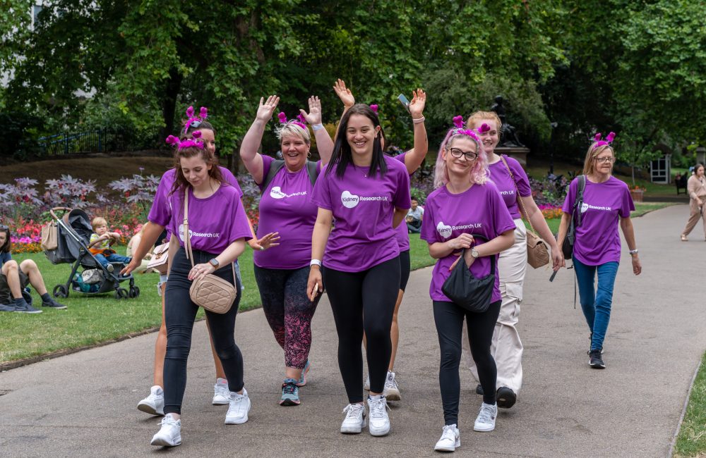 Walkers wearing purple t-shirts and waving hands in the air