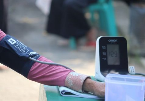 person in pink long sleeve shirt holding white samsung android smartphone