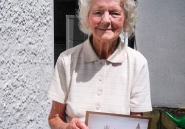Image of Iris holding up a framed image.