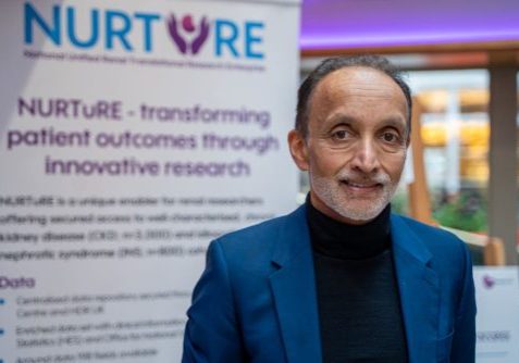 Main wearing black jumper and blue jacket