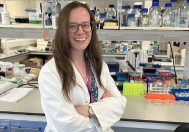 Female research standing in front of her lab bench