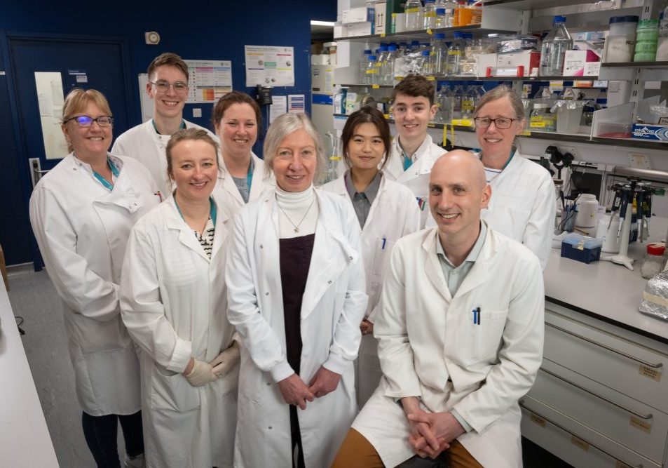 Staff and students lab shot (2) - BK virus lab visit March 2025 staff and students in a group shot in the lab, all are wearing white lab coats.
