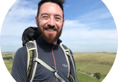 Man with beard, wearing a pack pack, waling in the countryside