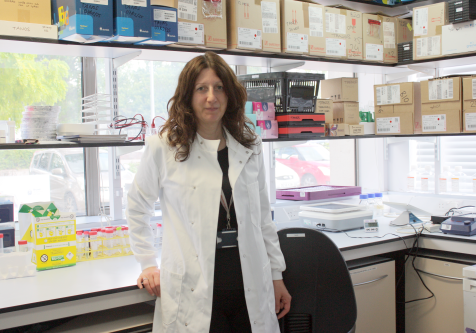 Dr Barbara Tanos Female researcher, wearing a white lab coat, in her research lab.