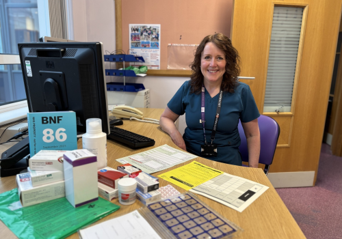 A female healthcare profession sat at her desk.